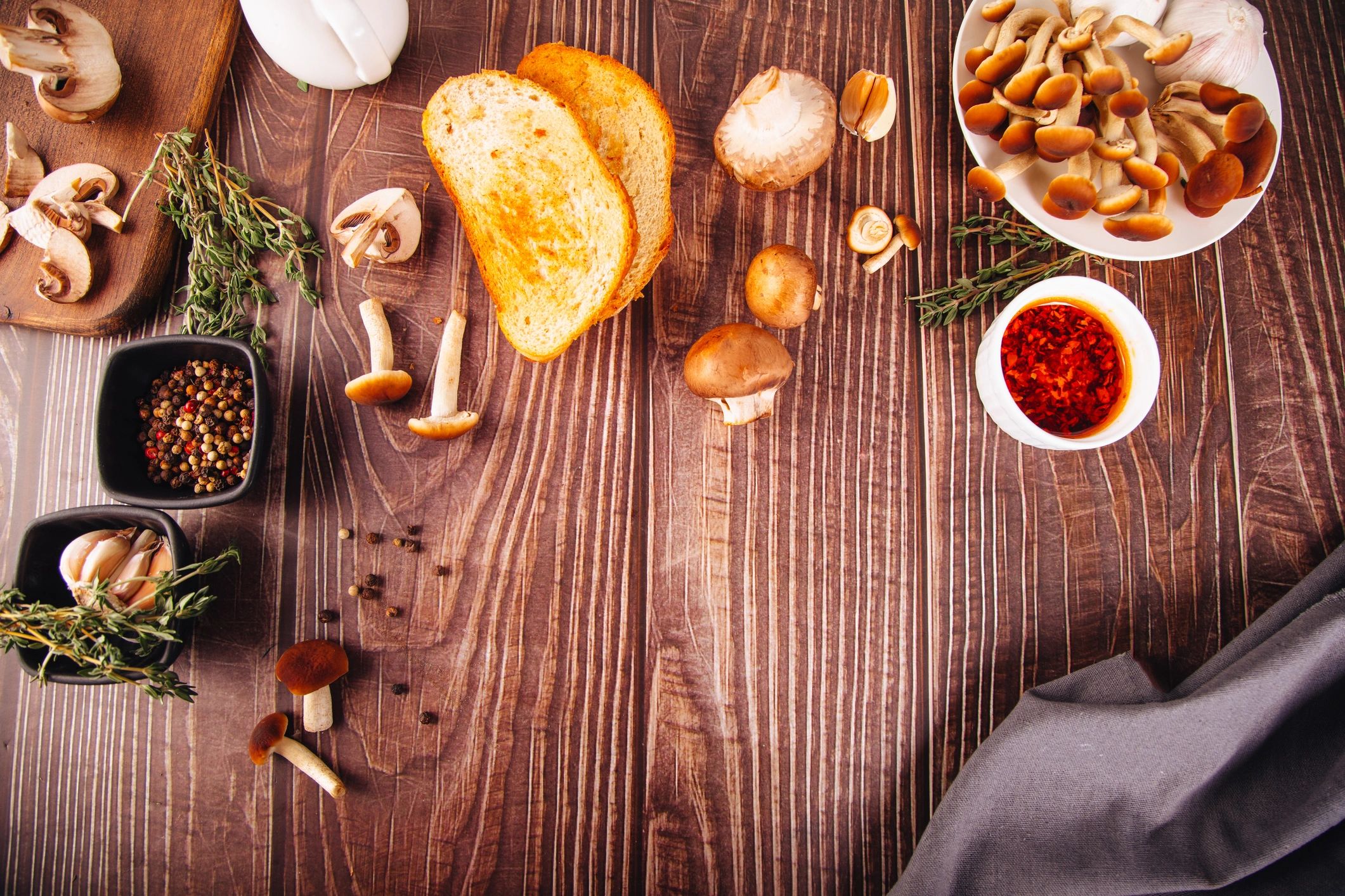Fresh mushrooms and herbs styled on a rustic table